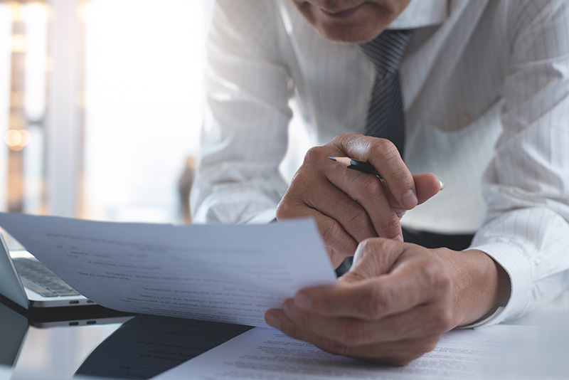 Businessman reading carefully terms conditions of business contract close up