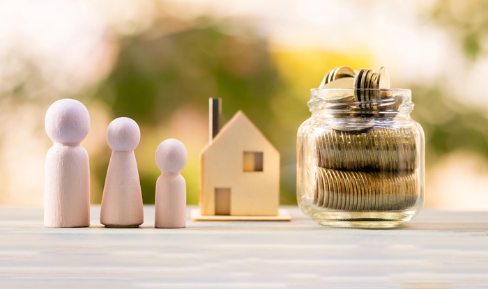 House model and family wood and bottle with gold coin inside of sunlight in the public park