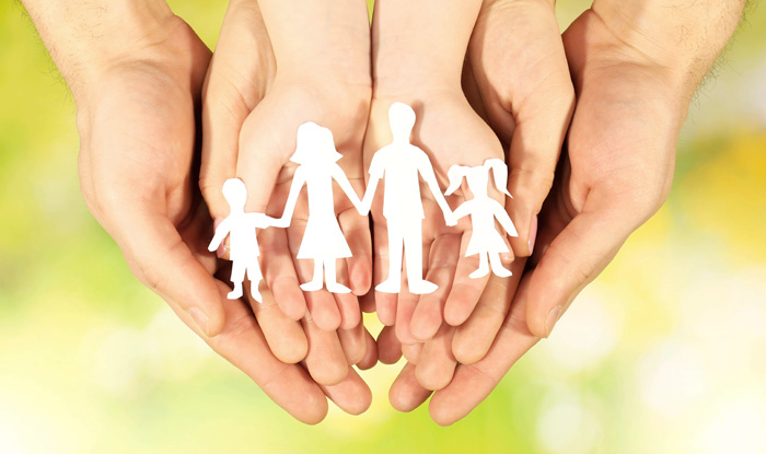 hands holding paper cutout family